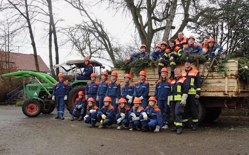 Weihnachten geht zu Ende - mit 69 ausgedienten Tannenbäumen Die erfolgreiche Sammlertruppe vor dem Traktor und Anhänger voller Weihnachtsbäume