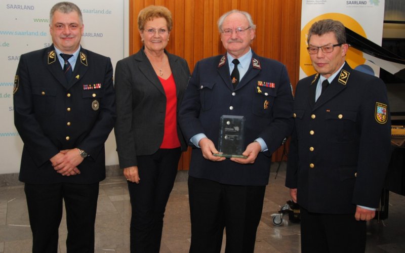 Ministerin Monika Bachmann übergibt den Preis an den Kreisfeuerwehrverband Saarlouis. Ministerin Monika Bachmann übergibt den Preis an den Kreisfeuerwehrverband Saarlouis, vertreten durch Bernd Paul, Brandinspekteur und Vorsitzender des Kreisfeuerwehrverbandes und Helmut Engeldinger, Geschäftsführer, im Beisein von Landesbrandinspekteur Bernd Becker.