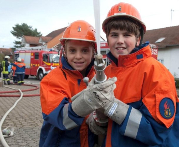 Zwei Jugendliche bei der Brandbekämpfung
